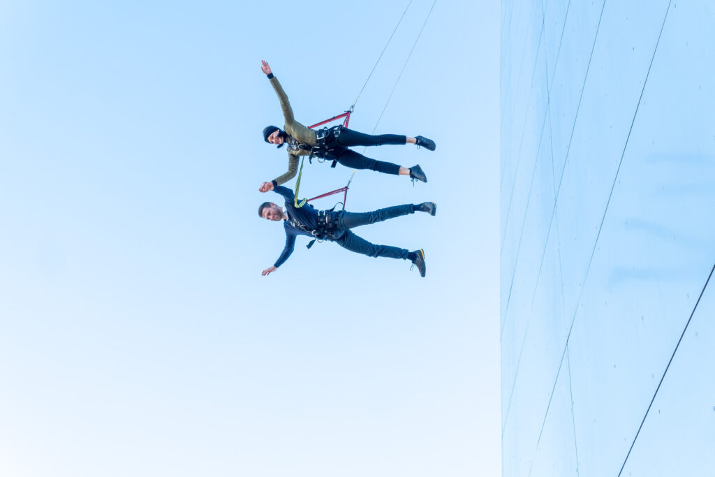 a man and woman jumping from a building